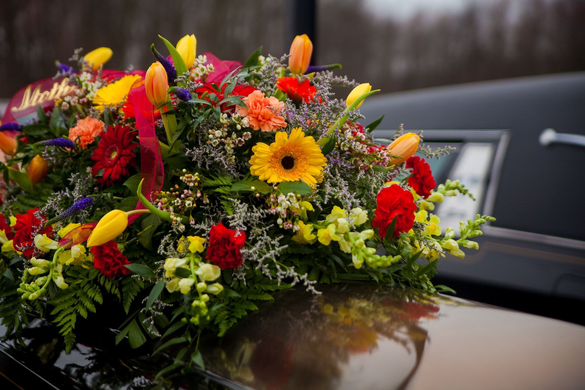 Funeral Casket and flowers next to hearse